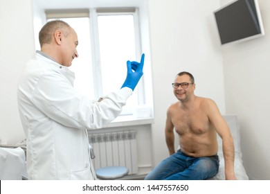 Doctor Urologist Puts A Medical Glove On The Arm To Examine The Patient's Prostate, Prostate Massage, Lymphatic Drainage.