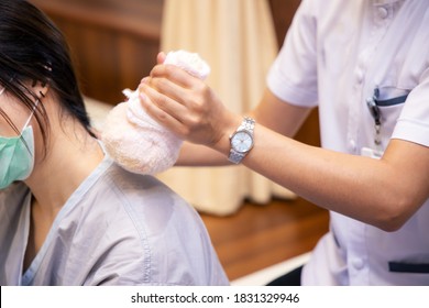 Doctor Use Herbal Compress For Abate Fared Ache Shoulder Or Back The Patient. Thai Traditional Massage Therapy Alternative Medicine. Selective Focus In The Patient Shoulder.