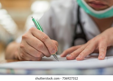Doctor use a pen writing about healthcare and remedy on paper or prescription document for a healthcare patient in hospital - Shutterstock ID 736927312