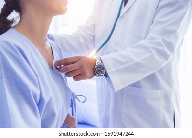Doctor use stethoscope, checking up heart beat, lunch of auscultation in doctor office at hospital. Patient worker has to get medical checkup every year for her health or medical checkup cardiologist - Shutterstock ID 1591947244
