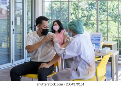 A doctor use syringe to injecting covid-19 vaccine into the Asian people in the hospital to prevent outbreak of coronavirus. Immunization, Covid-19 vaccination clinic, Coronavirus global pandemic.