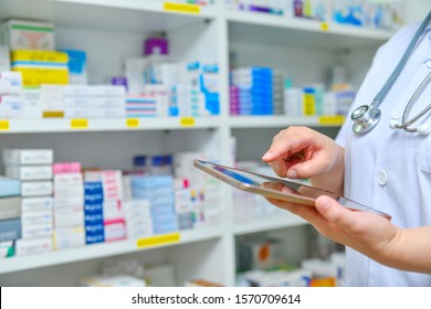 Doctor Using Computer Tablet For Search Bar On Display In Pharmacy Drugstore Shelves Background.Online Medical Concept.