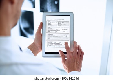 doctor is using a digital tablet to fill out the registration form. - Powered by Shutterstock