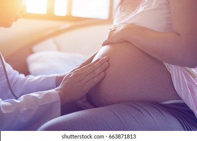 Doctor Using Hand And Stethoscope White Examining Pregnant Woman In Clinic,Medical Exam Concept,vintage Color Selective Focus