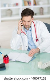 Doctor Using His Cell Phone To Discuss The Lab Results