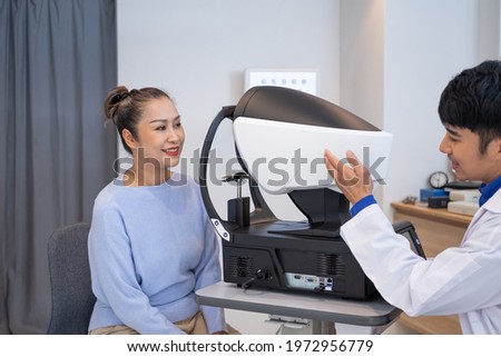 Doctor using penlight and Optometry frame equipment and do subjective refraction to  examine eye visual system of elder patient women with professional machine before made glasses.