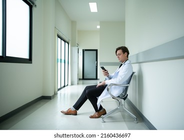 The doctor is using the phone to see the tasks that will be responsible for the day. to provide complete and complete treatment of patients