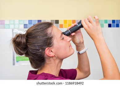 Doctor using refractometer for scientific test - Powered by Shutterstock