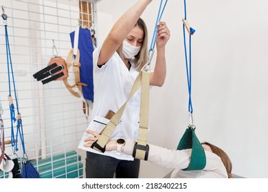 Doctor Using A Sling To Immobilize An Arm During Rehabilitation Therapy