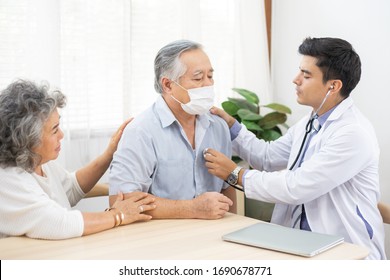 Doctor Using Stethoscope For Auscultate Asian Grandfather Patient With Face Mask While Older Woman Take Care Of Him, Life Insurance, Healthcare For Elderly, After Receive Covid-19 Vaccine