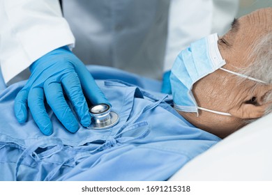 Doctor Using Stethoscope To Checking Asian Senior Or Elderly Old Lady Woman Patient Wearing A Face Mask In Hospital For Protect Infection And Kill Novel Coronavirus (2019-nCoV) Covid-19 Virus.