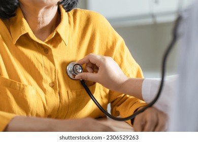 Doctor using a stethoscope checking patient stethoscope putting beat heart diagnose medical checkup cardiologist in examination room