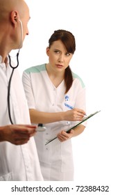 Doctor using stethoscope and dictating notes to the nurse