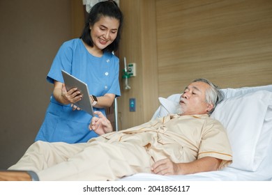 doctor using tablet computer  discussing with senior man patient lying on bed in hospital ward . Physiotherapist visiting and talking with  Disabled old male to physiotherapy in rehab  - Powered by Shutterstock