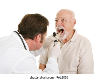 Doctor Using A Tongue Depressor And An Otoscope To Look Inside A Senior Patient's Mouth.  Isolated On White.