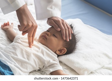 The Doctor Is Using Two Fingers To Press Down In The Middle Of The Baby's Chest, Which Is CPR In The Case That The Child Stops Breathing, To Health Care And Insurance Concept.