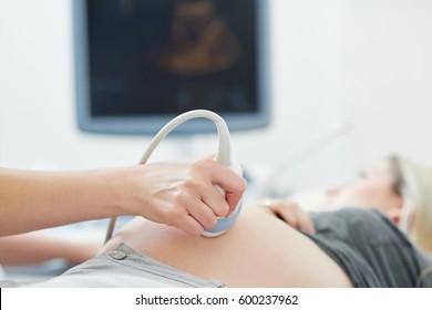 Doctor Using Ultrasound Equipment Screening Of Pregnant Woman.