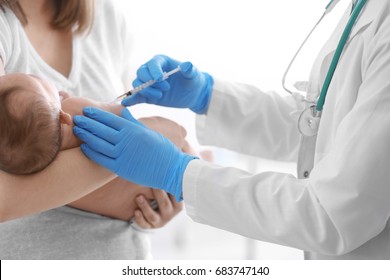 Doctor vaccinating cute baby in hospital
