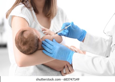 Doctor vaccinating cute baby in hospital