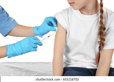 Doctor vaccinating little girl on white background, closeup