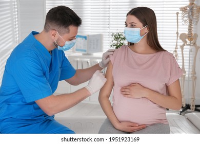 Doctor vaccinating pregnant woman against Covid-19 in clinic