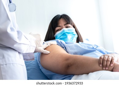 The doctor is vaccinating Prevent Covid-19 or Coronavirus for Asian fat woman, who wearing a surgical masks Lying in patient bed, to vaccine and health care concept.