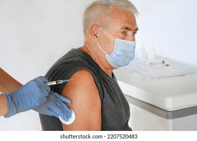 Doctor Vaccinating Senior Man In Clinic. Older People Vaccination. Doctor Giving Monkeypox Or COVID Vaccine Injection To Mature Man In Face Mask. Protection Of Elderly Patient. Old Man In Hospital