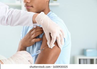 Doctor vaccinating teenage boy in clinic, closeup - Shutterstock ID 1630920325