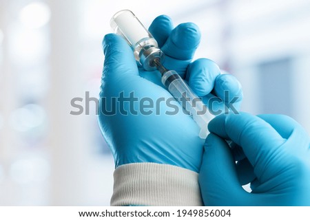 A doctor vaccinator holds a dose of a COVID-19 vaccine.