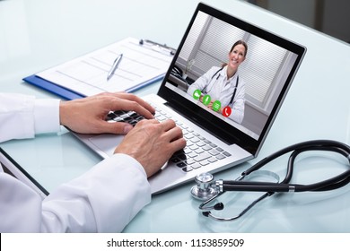 Doctor Video Conferencing On Laptop With His Female Colleague