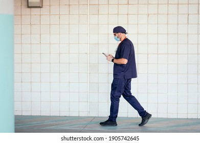 Doctor Walking Outside Hospital Using Smart Phone