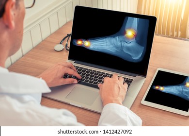 Doctor Watching A Laptop And Digital Tablet With X-ray Of A Foot With Pain Relief In The Ankle And Toes