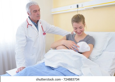 Doctor Watching Mother And Newborn Baby