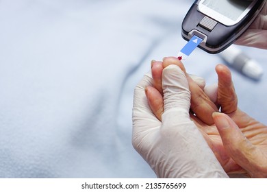 Doctor Wear Gloves Using Lancet On Finger For Checking Blood Sugar Level By Glucose Meter.
