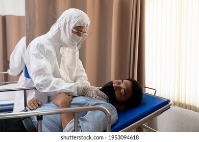 Doctor Wear Protection Suit Disinfecting, Face Mask And Face Shield Examining Sick Male Patient While Lying On Emergency Trolley In Patient Room In The Hospital. Health Care Concept