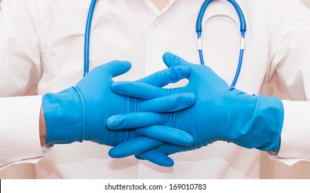 Doctor wearing blue sterilized surgical glove