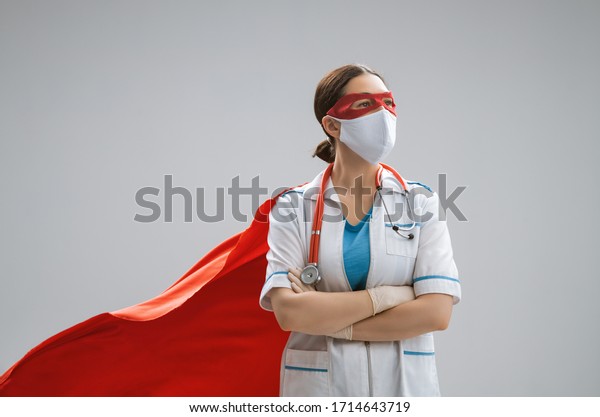 Doctor wearing facemask and\
superhero cape during coronavirus outbreak. Virus and illness\
protection, quarantine. COVID-2019. Super hero power for \
medicine.