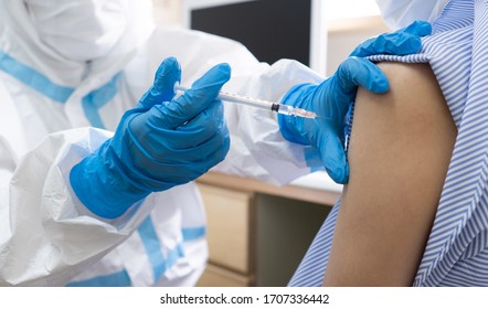 A Doctor Wearing Gloves Is Injecting The Vaccine To The Woman Patient In The Hospital. Covid-19, Coronavirus, Vaccine, Vaccination, Immunization, Medical, Healthcare, Herd Immunity Concept