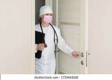 Doctor Wearing Medical Face Mask With Stethoscope Opens A Door Entering Room