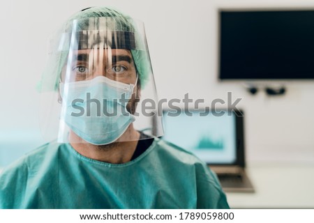 Doctor wearing ppe face surgical mask and visor fighting against corona virus outbreak - Health care and medical workers concept 