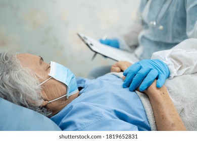 Doctor Wearing  PPE Suit New Normal To Check Asian Senior Or Elderly Old Lady Woman Patient Wearing A Face Mask In Hospital For Protect Infection Covid-19 Coronavirus.