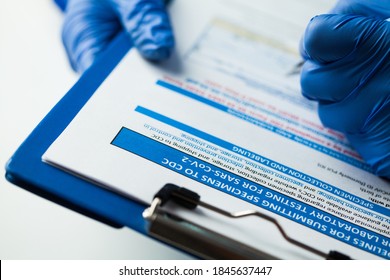 Doctor Wearing Protective Gloves Analyzing COVID-19 Info Data,writing Down Patient Report,laboratory PCR Specimen Saliva Collection Analysis And Submission Guidelines,Coronavirus Pandemic Crisis 