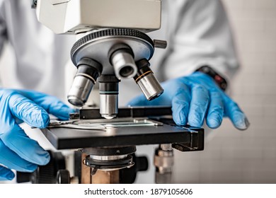 doctor wearing protective gloves using microscope researching corona virus microscopic cells testing vaccination cure, medical center lab china Wuhan world health organization research facilities