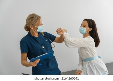 Doctor Wearing Protective Mask Against Covid, Elbowing Touching In Greeting With Patient