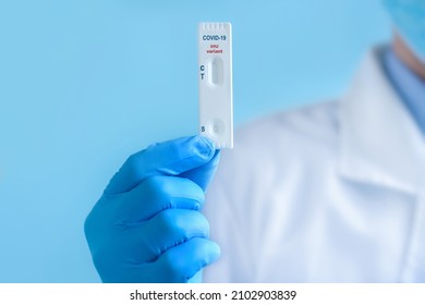 A doctor wearing a protective mask and gloves shows a rapid laboratory test for COVID-19 IHU variant strain to detect IgM and IgG antibodies to the new coronavirus.
