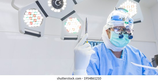 Doctor wearing surgical loupes during medical procedure, Surgery operating room with blue surgical gown suite perform heart surgery. Banner background.
Surgeon sewing on patient in cosmetic surgery. - Powered by Shutterstock