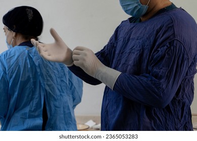 a doctor wearing a white gloves in a sterile environment - Shutterstock ID 2365053283