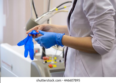 Doctor wears gloves blue rubber gloves on their hands. The doctor prepares for the procedure in a medical office. The health of the person needs the assistance of medicine.