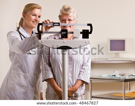 Doctor weighing senior woman in doctor office