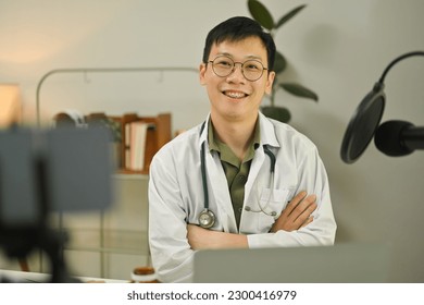 Doctor in white coat making medication advise via online podcast, online medical blog from home - Shutterstock ID 2300416979